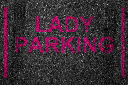 与油漆文本词位女士停车，女司机驾驶停止空间保留的停车场插槽