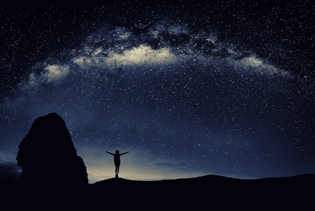在晚上的年轻人站在星空下.旅游概念照片