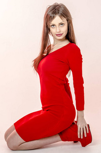 年轻的女孩，穿着时髦红色紧身迷你裙和红色的高跟鞋和平台参加舞会穿的美丽图
