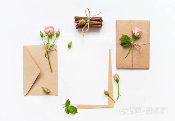 信, 信封和白色背景上的礼物.邀请卡或用粉红玫瑰的情书.