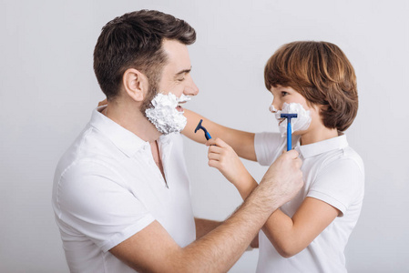 高兴的男人和男孩准备刮胡子