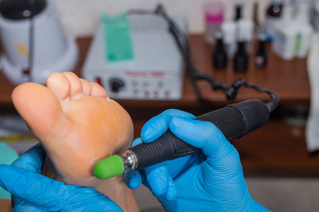 修脚死皮去除脚锉刀女人在美甲沙龙照片