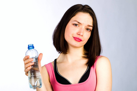 在与一瓶饮用水运动服的年轻女子