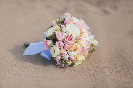 美丽的复古婚礼花束花玫瑰在沙滩上