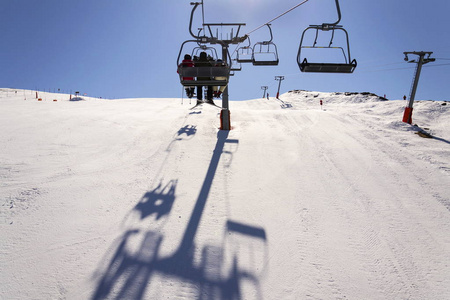 在阳光灿烂的冬天的阿尔卑斯山，非盟滑雪缆车的人