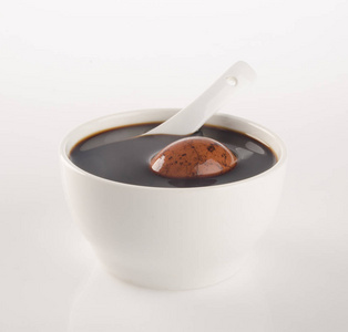 中国传统草药和背景上的药汤照片