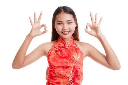 亚洲女孩穿着旗袍的显示 Ok 的手势