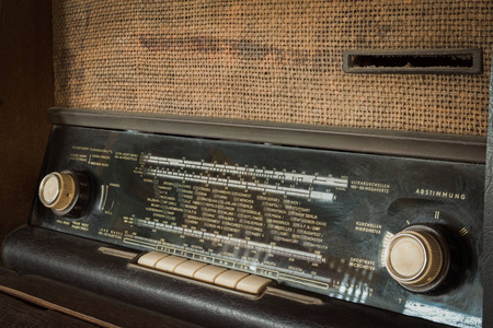 木制老式古董模拟收音机，木制桌子上有收音机表盘。