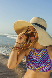 女孩在海滩穿海滩夏天帽子和太阳镜 admiri
