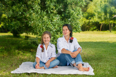 母亲和女儿坐在一棵橡树下