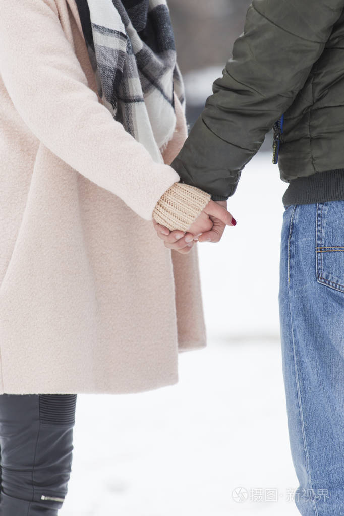 情侣牵手走在雪地上