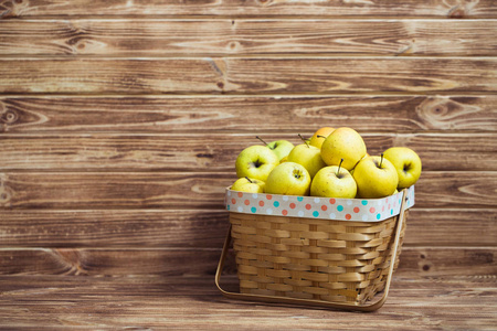 在一个木制的背景一只篮子里的金苹果