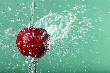 红红的苹果，在水中滴眼液对绿色背景
