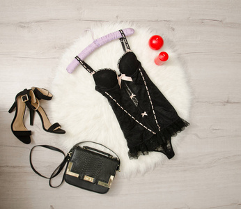 黑色蕾丝胸衣 鞋子 手袋和上一条白色皮毛的红蜡烛。时尚概念，顶视图