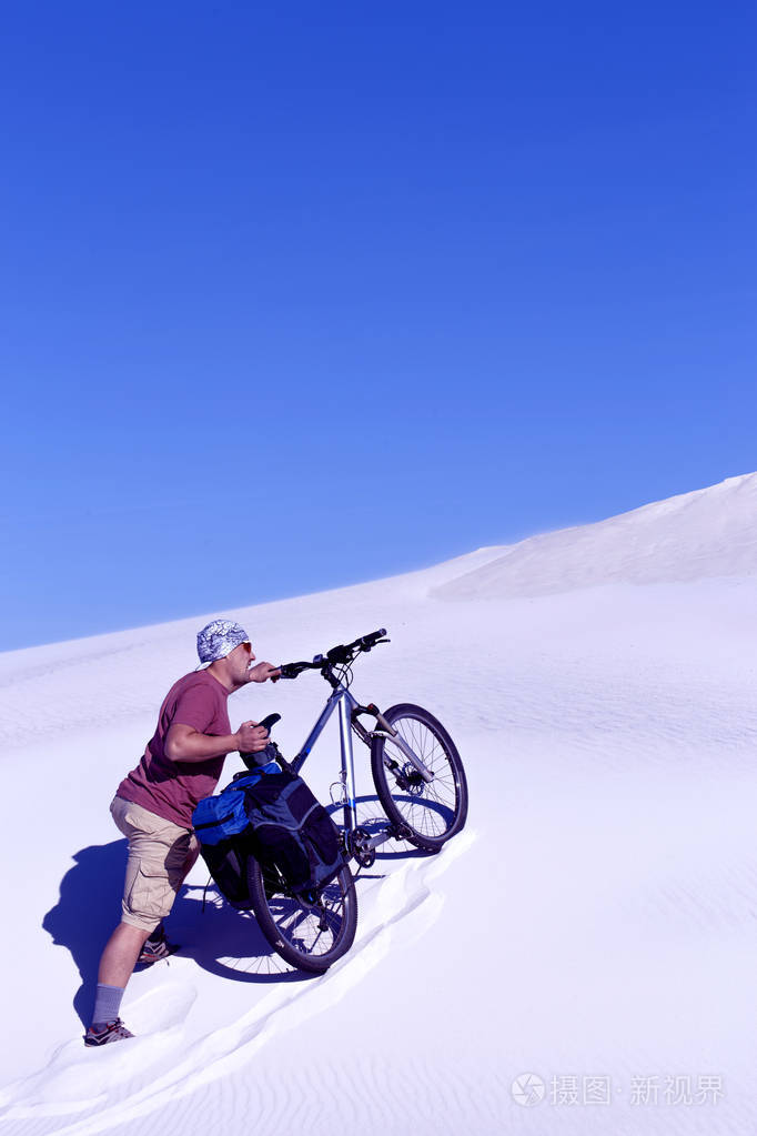 骑着自行车在沙漠中旅行的人