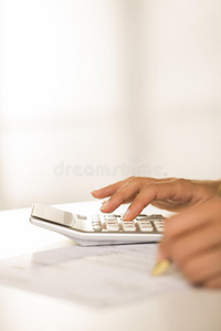 女人的手拿着计算器和笔，会计。