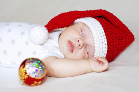 戴着新年帽和圣诞树装饰的熟睡婴儿