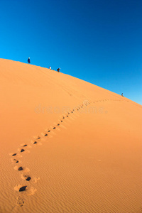 行走在沙丘和脚印上的人们图片