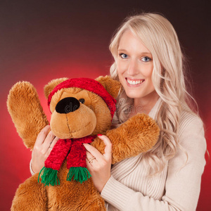 漂亮的金发女孩抱着一只泰迪熊图片