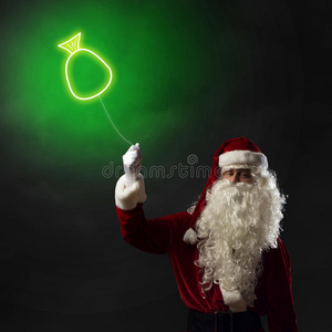 圣诞老人手里拿着一个象征圣诞包的灯