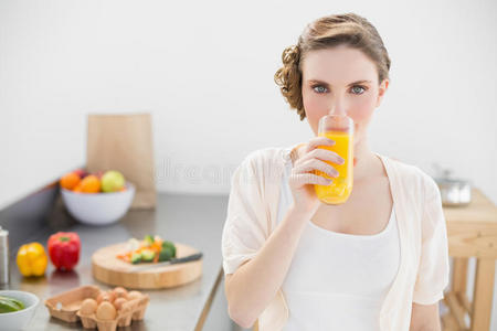 站在厨房里喝橙汁的美女