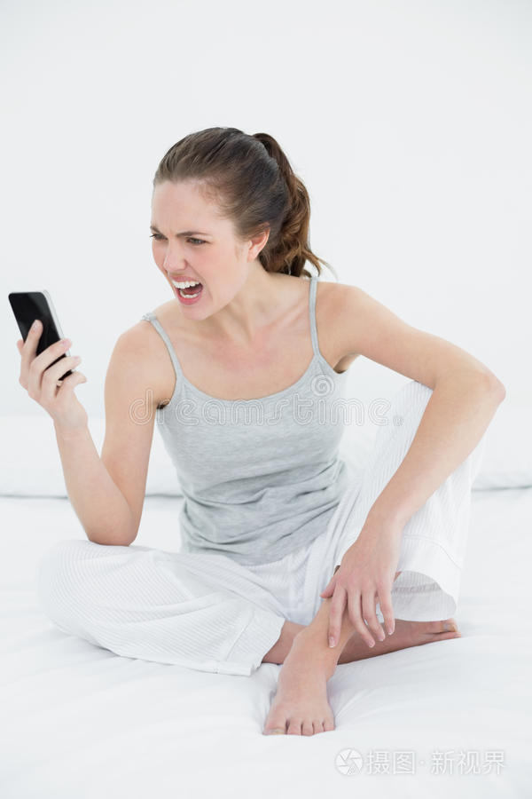 女人在床上对着手机大喊