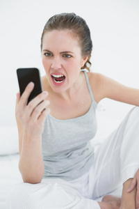 女人在床上对着手机大喊