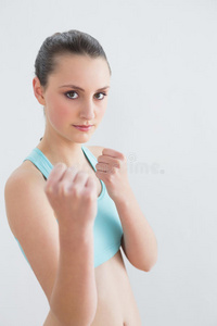 运动型女性紧握拳头靠墙图片