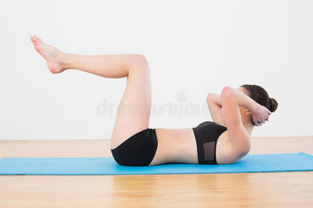 运动型健身女在健身室做仰卧起坐