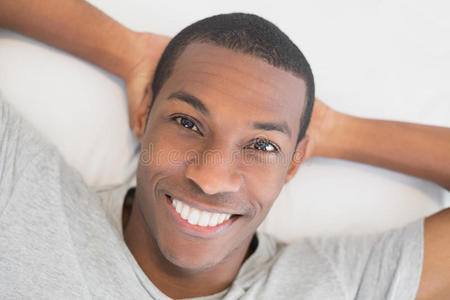 微笑着躺在床上的年轻非洲男人