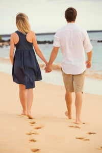 夕阳沙滩上漫步的浪漫幸福夫妻