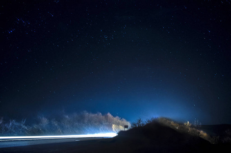 美丽的星星在夜空中靠近道路与汽车灯光轨道