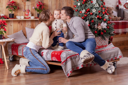 幸福的家庭，在附近圣诞树在家里的床上