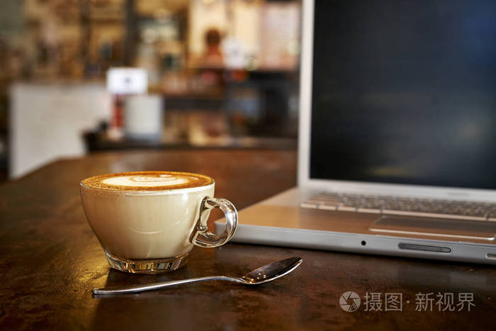 笔记本电脑与新鲜杯咖啡