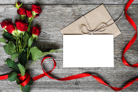 空白白的贺卡和信封用红玫瑰鲜花