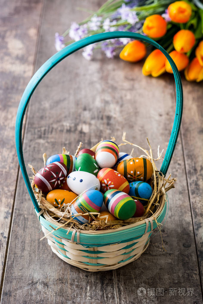 在木制的桌子上一篮子的复活节彩蛋