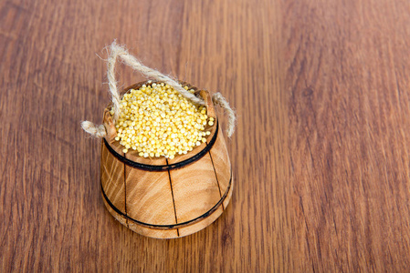木制的桌子上小米的木桶里。最有用和最美味的麦片粥它