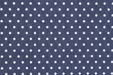 深蓝色背景花纹深蓝色的牛仔与白色圆点花纹织物背景照片