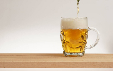 杯光啤酒在木板上