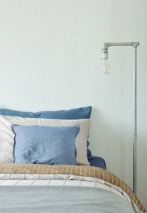 工业式的阅读灯在蓝色和灰色的颜色方案被褥的床边