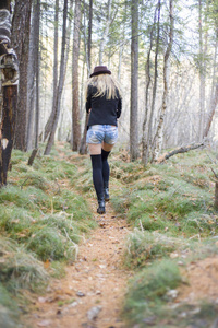 在秋天森林散步的美丽的年轻女孩