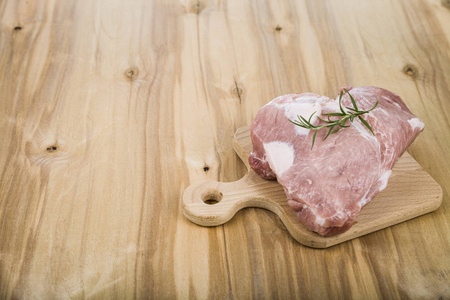 迷迭香在桌子上木板上的生猪肉。烹饪的 f