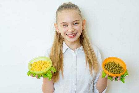 快乐健身女孩抱着罐头豌豆和玉米