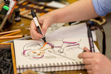 年轻的艺术家使素描用水彩笔在纸上
