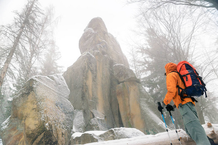 男人看着岩石，在群山，野生地方岩石覆盖着雪