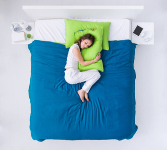 袅袅蜷缩在床上的女人摄影图