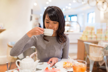 女人享受在咖啡店里的饮料