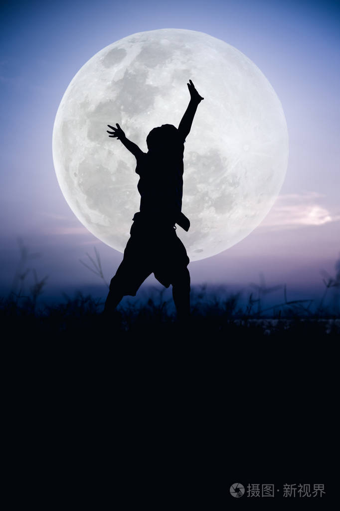 剪影的孩子享受和在草地上跳跃的背影