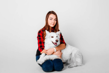 一个十几岁的年轻女孩与她的狗在白色背景上的工作室的肖像