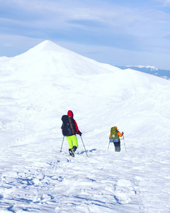 冬季徒步旅行。在山里徒步旅行带着背包和帐篷雪的冬天